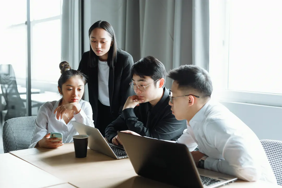 Équipe au travail sur des ordinateurs portables dans un bureau moderne et lumineux